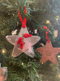 Handpunched tin ornaments: one natural star with three chilis added, one copper star.